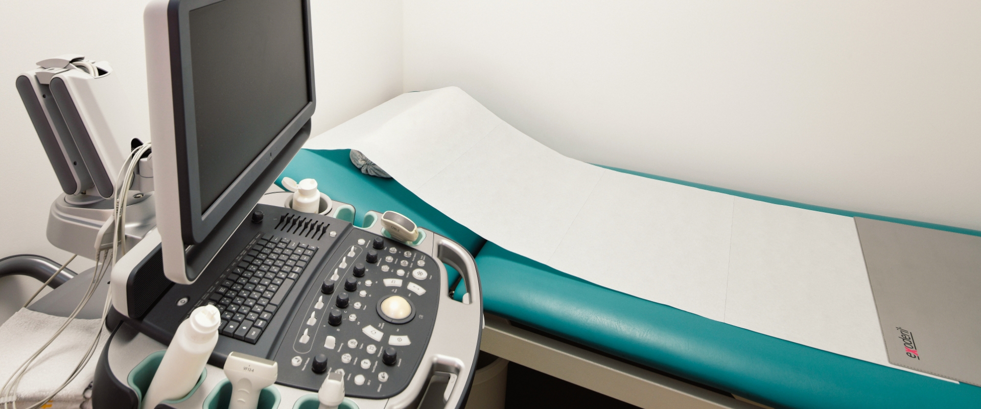 Blick einen aufgeräumten Schreibtisch mit Monitor und Drucker, dahinter eine Fototapete mit Birkenwald und einem Bücherregal